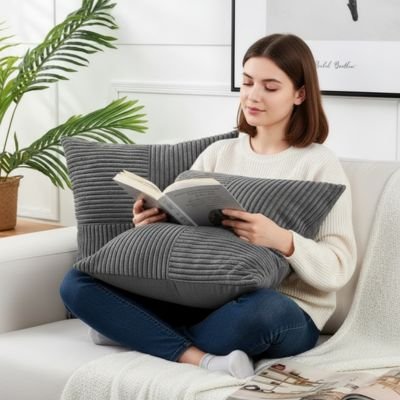 Housses de coussins grises femme lit un livre