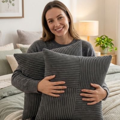 Housses de coussins grises femme prend les coussins dans sa main